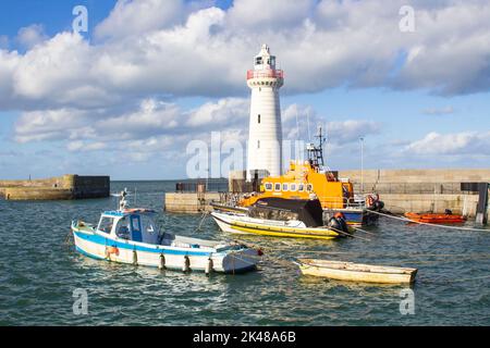 30 settembre 2022 le barche ormeggiate nel porto di Donaghadee, Irlanda del Nord, sotto la luce solare soffusa dei primi mesi dell'autunno, sotto l'ombra del faro locale. Foto Stock