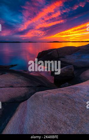 Una bella vista della costa rocciosa al tramonto con un cielo colorato Foto Stock