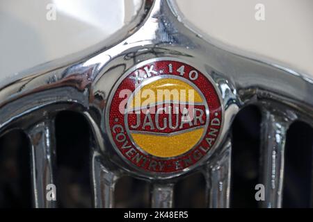 Logo Jaguar XK140 rosso e oro sulla parte superiore della griglia del radiatore cromata Foto Stock