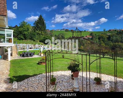 Kitzeck im Sausal, Austria - 20 settembre 2022: Guesthouse con piscina e persona non identificata rilassarsi in letto piscina nel tuo villaggio di montagna nel sud di St Foto Stock