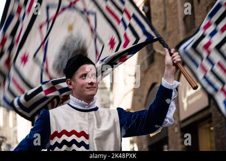 Siena, Toscana, Italia - Agosto 14 2022: Portatore di bandiera con la Bandiera o Standard dell'Istrice o Crested Procopine Contrada al Corteo storico Pag Foto Stock