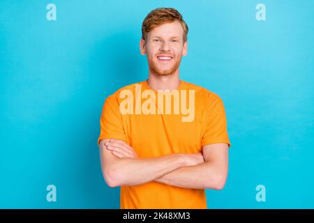 Foto di un bell'uomo allegro soddisfatto con capelli di zenzero vestito giallo t-shirt braccia incrociate isolato su sfondo di colore turchese Foto Stock