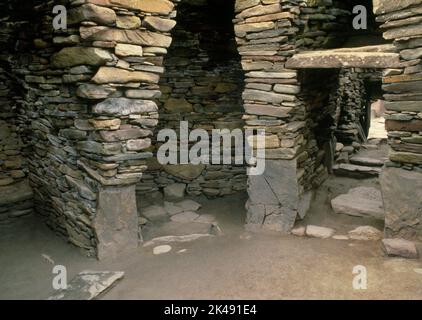 Visualizza WNW all'interno della Iron Age Wheelhouse II a Jarlshof Settlement, Sumburgh, Shetland, Scozia, Regno Unito, che mostra moli radiali, compartimenti e un serbatoio in pietra. Foto Stock