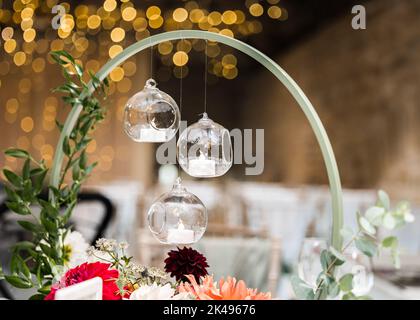 Bella decorazione del tavolo di nozze a lume di candela con fiori e luci scintillanti fuori fuoco. Prima colazione di nozze. Foto Stock