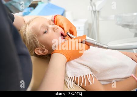 Il bambino viene trapanato con un dente di foratura Foto Stock