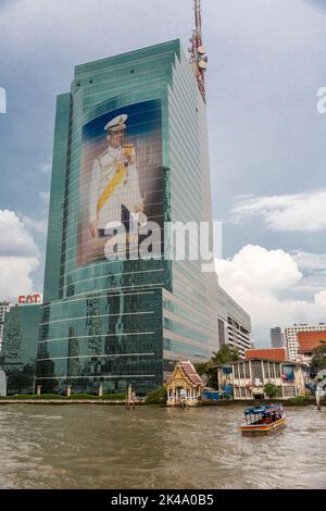 Bangkok, Tailandia. Torre Gatto (Autorità per le Garanzie nelle Comunicazioni di Thailandia), con immagine del re, visto dal fiume Chao Phraya. Foto Stock