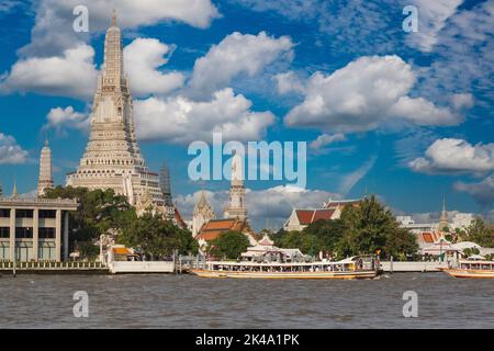 Bangkok, Tailandia. Mattina barca fluviale sul fiume Chao Phraya prende pendolari a lavorare. Il Wat Arun tempio in background. Foto Stock