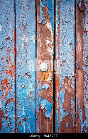 Vernice blu da peeling su una porta con pannello di legno Foto Stock