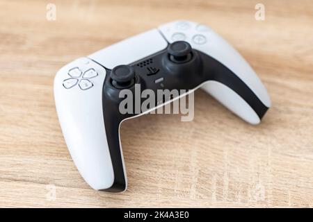 OSTRAVA, REPUBBLICA CECA - 17 MARZO 2022: Il controller Sony DualSense viene utilizzato per la console di gioco PlayStation 5 su un tavolo di legno Foto Stock