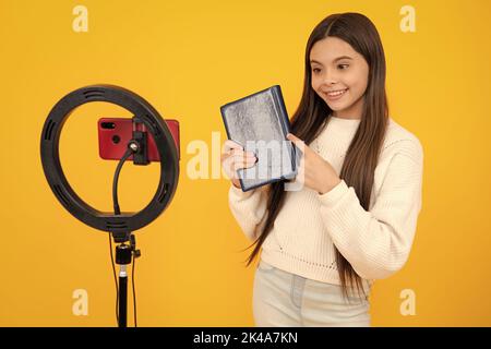 Teenager bambino scuola ragazza registrazione video tutorial per i social media con smartphone. Influencer adolescente creazione di nuovi contenuti per il blog, mentre Foto Stock