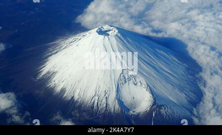 Immagini rare angolo di vista dall'alto di Mt. Fuji montagna e neve bianca coprire su di esso e nuvole chiare e chiaro cielo blu pulito che spara dall'aereo. Foto Stock