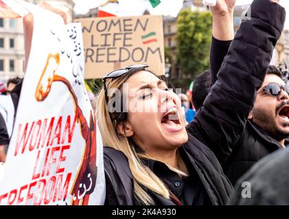 Una donna canta slogan anti-regime durante una protesta di solidarietà con le donne iraniane, come parte delle proteste pianificate a livello mondiale contro il regime della Repubblica islamica dell'Iran dopo la morte di Mahsa Amini a Trafalgar Square, Londra, Regno Unito il 1 ottobre 2022. La morte di Mahsa Amini, 22 anni, dal Kurdistan, arrestato dalla polizia morale di Teheran per non aver indossato correttamente il suo hijab ha inviato un'ondata di proteste in Iran e in tutto il mondo. Amini è stata portata in un centro di detenzione dove è crollata e morì in ospedale. Il motivo della sua morte non è chiaro. Presidente iraniano Ebrahim Raisi Foto Stock