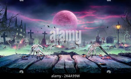 Halloween - Zombie Rising on Wooden Table - Sheletons Party in Graveyard a Spooky Nights with Blood Moon Foto Stock