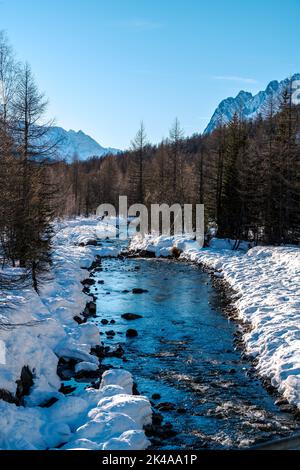 Inverno in Val Ferret, Courmayeur, Italia, con un torrente beatiful e freddo. Foto Stock