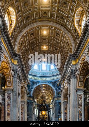 Un'immagine verticale dell'interno della Basilica di San Pietro a Roma, Italia, con sontuosi soffitti a volta e dorati Foto Stock