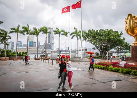 Hong Kong, Cina. 1st Ott 2022. Due donne che indossano cappellini con la bandiera della Cina visto che prendono selfie insieme alla Piazza Golden Bauhinia. La Cina celebra il 73rd° anniversario della sua fondazione, avvenuta il 1 ottobre. (Credit Image: © Alex Chan Tsz Yuk/SOPA Images via ZUMA Press Wire) Credit: ZUMA Press, Inc./Alamy Live News Foto Stock