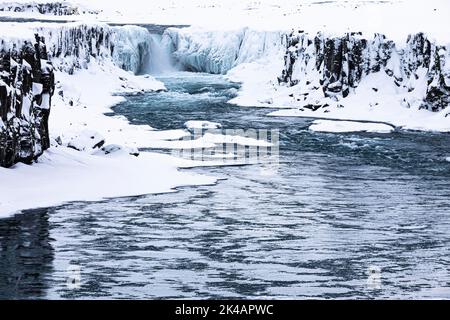 Selfoss cascata con il fiume Joekullsa a Fjoellum, rocce ghiacciate e innevate e costa, Islanda settentrionale Eyestra, Islanda Foto Stock