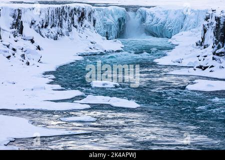 Selfoss cascata con il fiume Joekullsa a Fjoellum, rocce ghiacciate e innevate e costa, Islanda settentrionale Eyestra, Islanda Foto Stock