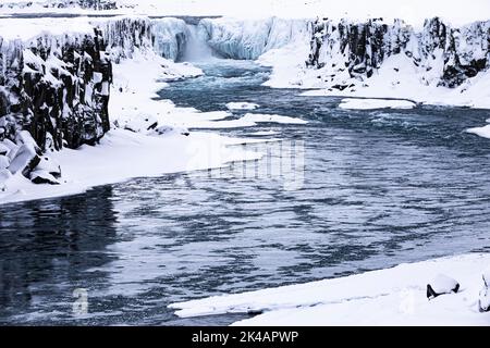 Selfoss cascata con il fiume Joekullsa a Fjoellum, rocce ghiacciate e innevate e costa, Islanda settentrionale Eyestra, Islanda Foto Stock