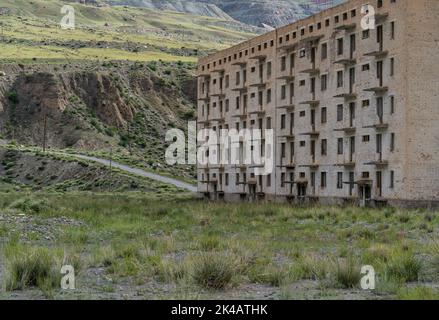 Edifici residenziali sovietici abbandonati e incompleti nella città mineraria di Enilchek, Kirghizistan Foto Stock