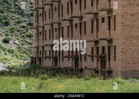 Edifici residenziali sovietici abbandonati e incompleti nella città mineraria di Enilchek, Kirghizistan Foto Stock