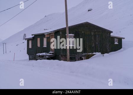 Singola casa in legno rialzata nel paesaggio invernale neve di Longyearybyen, Svalbard Foto Stock