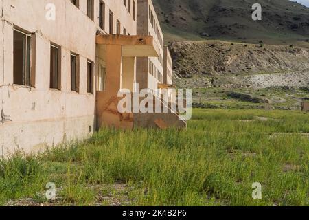 Blocchi di appartamenti abbandonati incompiuti nella città mineraria di Enilchek, Kirghizistan Foto Stock