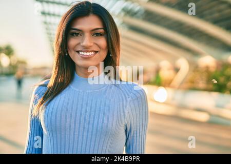 Bella donna ispanica sorridente confidente in città Foto Stock