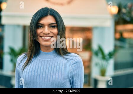 Bella donna ispanica sorridente confidente in città Foto Stock