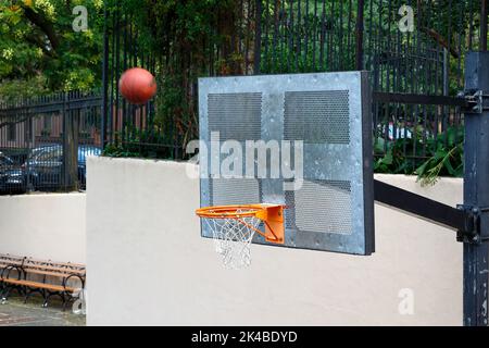Una pallacanestro che vola attraverso l'aria verso il backboard con un risultato sconosciuto se andrà nel cerchio. Foto Stock