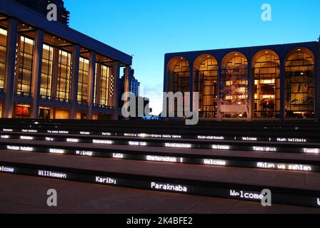 Il Steps of Lincoln Center Performing Arts Center a New York City accoglie gli ospiti di notte con messaggi di saluto illuminati in lingue straniere Foto Stock