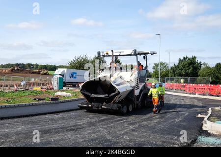 asfaltatrice posa asfalto su una nuova strada Foto Stock