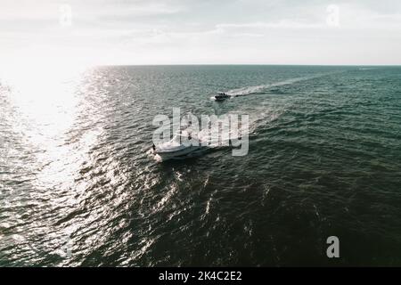 Una vista aerea di una barca a vela in un mare al tramonto Foto Stock