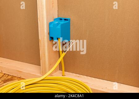 Cablaggio elettrico in rame nella parete della casa. Costruzione domestica, rimodellamento e concetto di riparazione di elettricità. Foto Stock