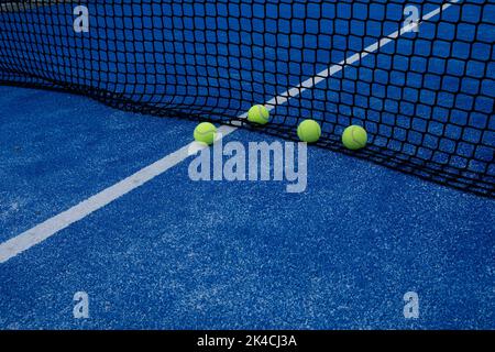 diverse palle in rete su un campo da tennis blu paddle Foto Stock