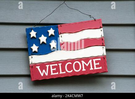 Una bandiera decorativa americana in legno, appende sul lato di una casa dalla porta d'ingresso Foto Stock