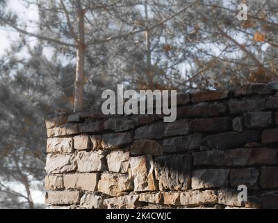 Un muro di pietra con un'ombra gettata sopra di esso in campagna Foto Stock