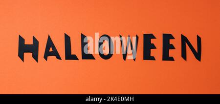 Lettere di Halloween con lettere nere su sfondo arancione. Sfondo di Halloween. Spazio di copia Foto Stock