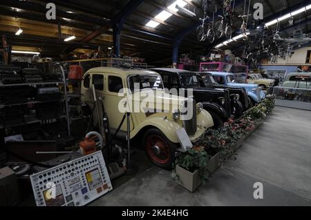 Una collezione di auto e biciclette a strapiombo e una rastrelliera di vecchie macchine da scrivere in mostra al New ZealandÕs National Transport & Toy Museum di Wanaka, Foto Stock