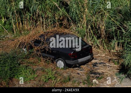 Corfù, Grecia. 02 settembre 2022: Auto vecchia abbandonata, nascosta nei cespugli. Foto Stock
