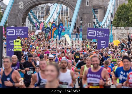 Tower Hill, Londra, Regno Unito. 2nd Ott 2022. Circa 50.000 persone partecipano alla maratona di Londra TCS 2022, tra cui i migliori corridori d'élite del mondo. Atleti come la campionessa olimpica Kenenisa Bekele, la vincitrice di 2021 uomini etiopico Sisay Lemma e la vincitrice di donne keniota Joyciline Jepkosgei saranno probabilmente presenti sul fronte. Anche l'atleta di sedie a rotelle David Weir si augura un posto di primo piano. La massa dei corridori di divertimento & del randello sta seguendo con molti che alzano le grandi somme per carità & spesso funzionare in vestito di fantasia. Massa di divertenti corridori che attraversano il Tower Bridge Foto Stock