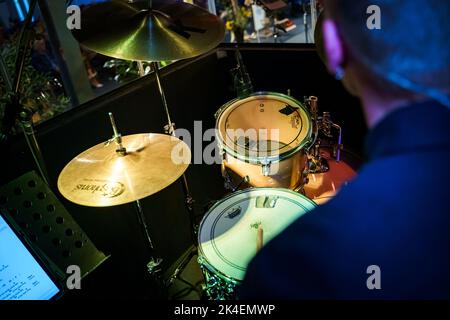 Il batterista con le cuffie suona il drum kit in studio Foto Stock