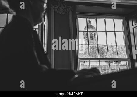 Vecchio municipio della città frisone di sneek con l'orologio della chiesa protestante attraverso la finestra Foto Stock