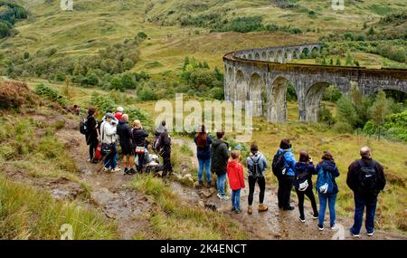TRENO A VAPORE JACOBITE GLENFINNAN VIADOTTO SCOTLAND SPETTATORI SUL SENTIERO IN ATTESA CHE IL TRENO ARRIVI Foto Stock