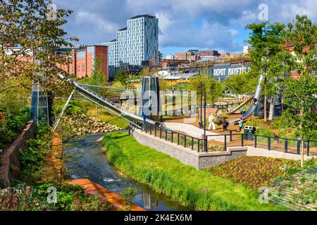 I bambini scivolano a Mayfield Park, con base intorno al fiume Medlock, Manchester, Inghilterra, Regno Unito. Pochi giorni dopo l'apertura al pubblico nel settembre 2022. Foto Stock