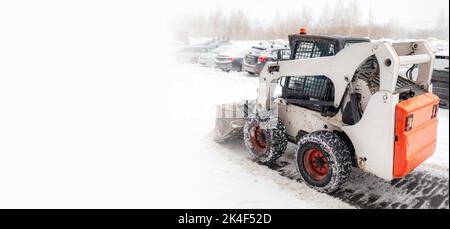 Sgombero neve. Il trattore si stacca dopo un'intensa nevicata. Un grande trattore arancione rimuove la neve dalla strada e libera il marciapiede. Pulizia delle strade Foto Stock