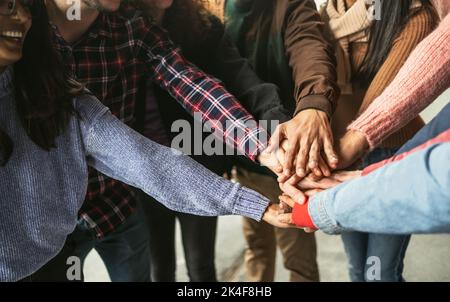 Amici giovani felici che si divertono a impilare le mani all'aperto - concetto di generazione millenaria della gente dei giovani Foto Stock