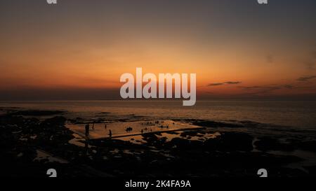 Nuotatori al tramonto, in una bella serata nel mese di agosto. Godendo della piscina di acqua di mare al Westward ho. Foto Stock