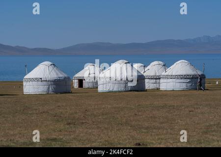 Campo turistico panoramico di yurt nomade sulle pianure del lago di Song Kul, Kirghizistan Foto Stock