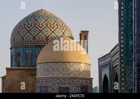 Zoom di motivi e texture delle cupole piastrellate dorate e blu in Shah-i-Zinda al tramonto, Samarcanda Foto Stock